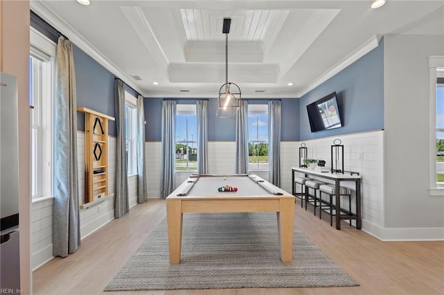 recreation room featuring a wainscoted wall, light wood-style flooring, a tray ceiling, and ornamental molding