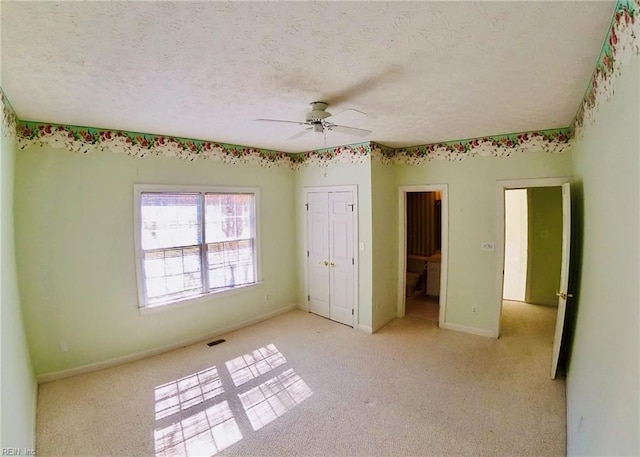 unfurnished bedroom featuring baseboards, visible vents, a ceiling fan, a textured ceiling, and a closet