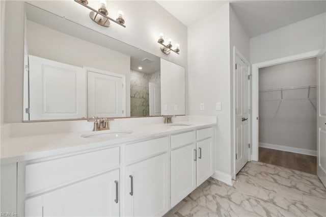 full bath featuring double vanity, marble finish floor, a shower stall, and a sink