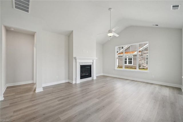 unfurnished living room featuring visible vents, wood finished floors, and a glass covered fireplace