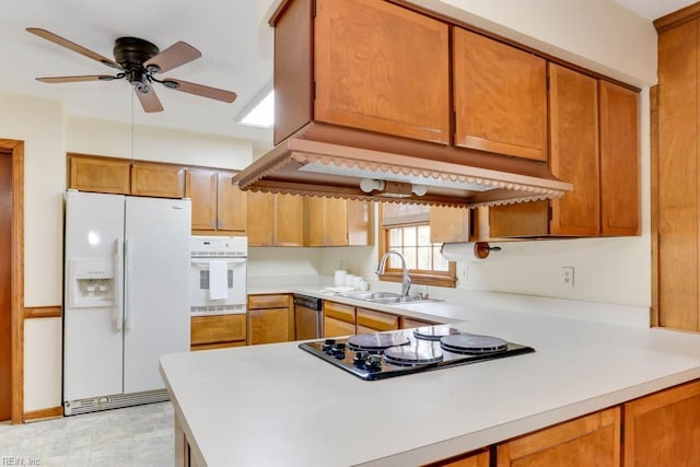 kitchen featuring white appliances, light countertops, a sink, and brown cabinetry