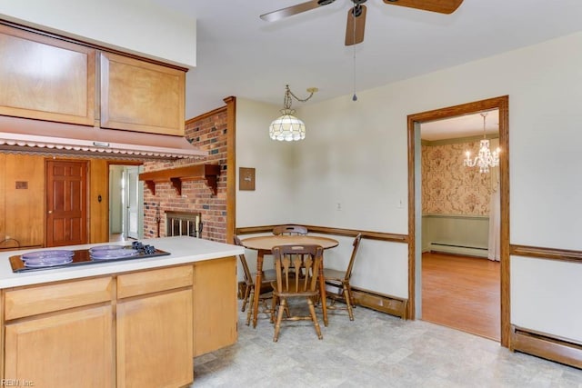 kitchen featuring a wainscoted wall, a fireplace, black electric stovetop, and a baseboard heating unit