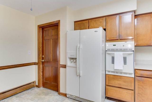 kitchen with a baseboard heating unit, light countertops, white appliances, and brown cabinetry