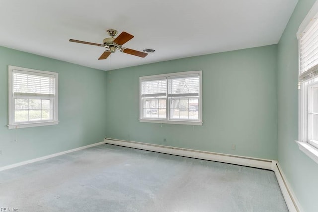 empty room featuring a wealth of natural light, a baseboard radiator, carpet floors, and baseboards