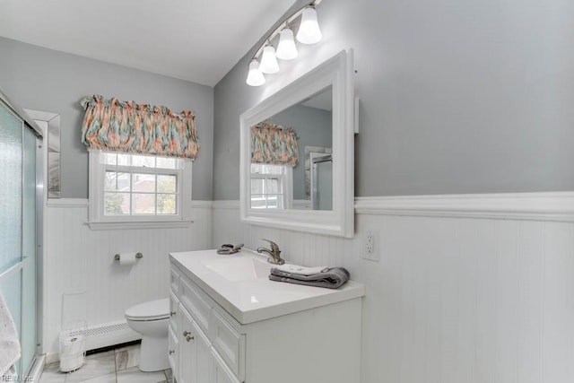 bathroom with toilet, a wainscoted wall, vanity, baseboard heating, and a shower with door