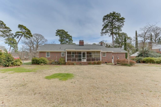 back of property with brick siding, a chimney, and a sunroom