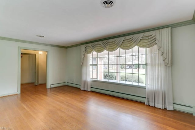 spare room featuring visible vents, crown molding, and wood finished floors