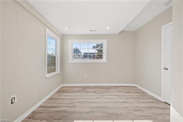 unfurnished room with light wood-type flooring, visible vents, baseboards, and recessed lighting