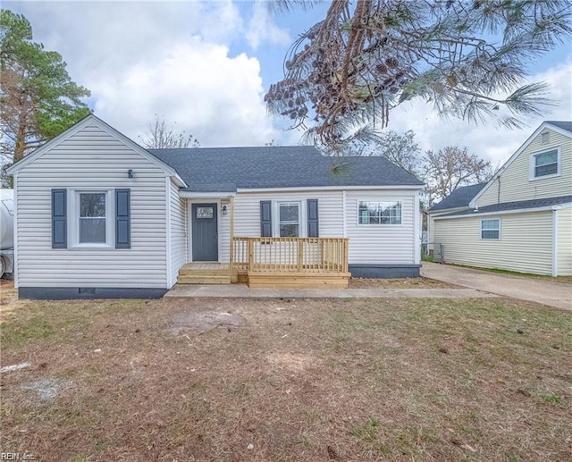 view of front of home with crawl space, a shingled roof, and a front lawn