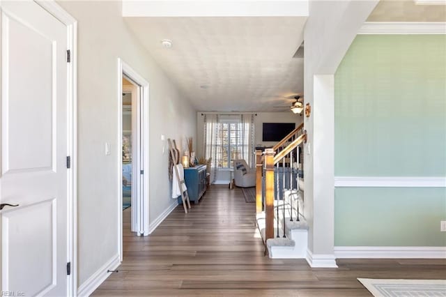 entryway with wood finished floors, ceiling fan, baseboards, and stairs