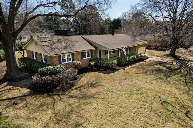 ranch-style house featuring a front yard, brick siding, and an attached garage