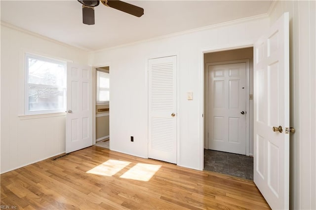 unfurnished bedroom with light wood-type flooring, ceiling fan, and crown molding