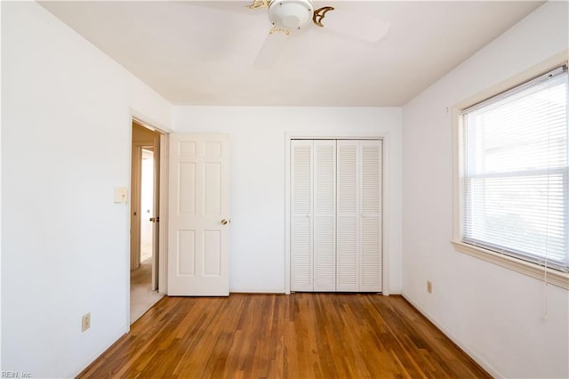 unfurnished bedroom featuring a closet, a ceiling fan, and wood finished floors