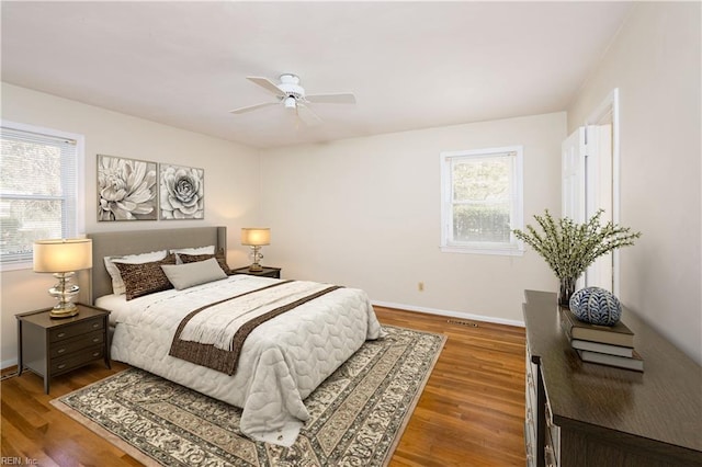 bedroom featuring baseboards, wood finished floors, and a ceiling fan