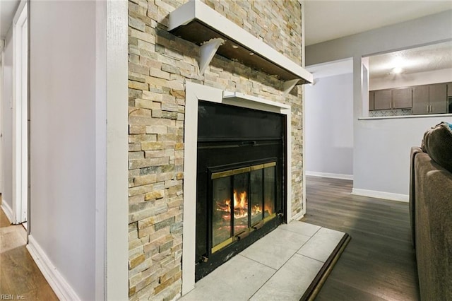 details with baseboards, wood finished floors, and a glass covered fireplace