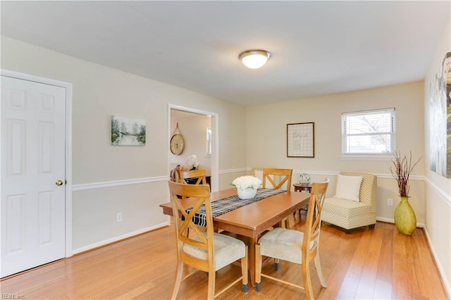 dining area with baseboards and light wood finished floors