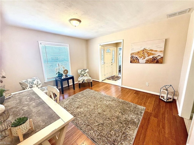 office space featuring wood finished floors, visible vents, and baseboards