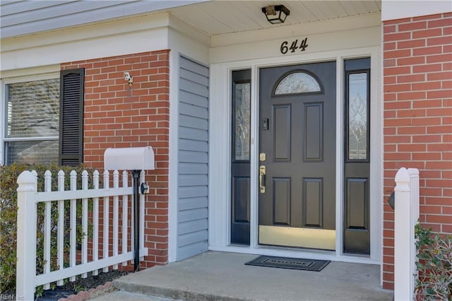 doorway to property featuring brick siding