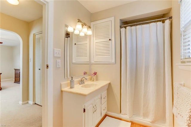 full bathroom with curtained shower, vanity, and baseboards