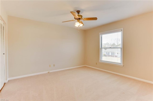 spare room with light carpet and baseboards