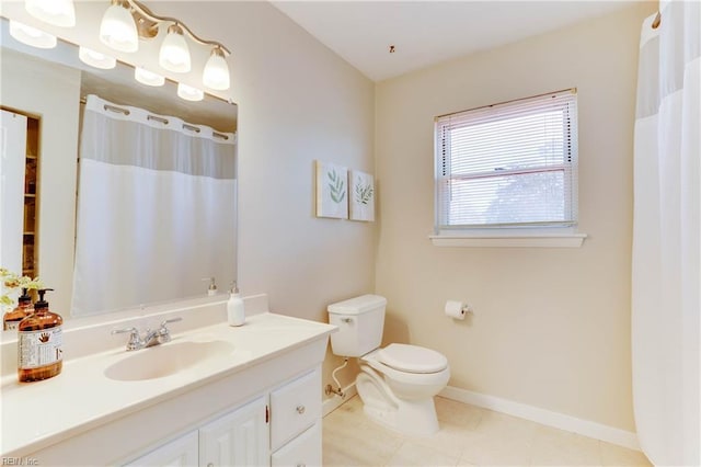 bathroom featuring curtained shower, toilet, vanity, baseboards, and tile patterned floors