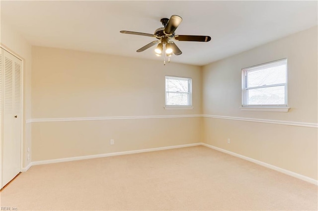 empty room featuring baseboards and light colored carpet