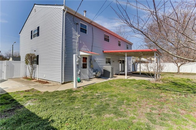 rear view of house with central AC unit, a lawn, a patio, a gate, and fence