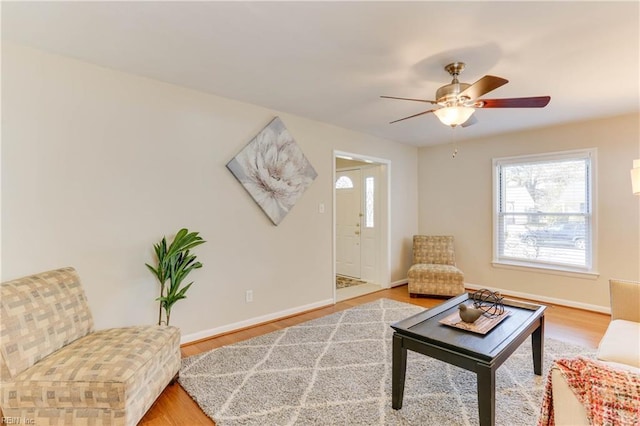 living area featuring plenty of natural light, wood finished floors, and baseboards