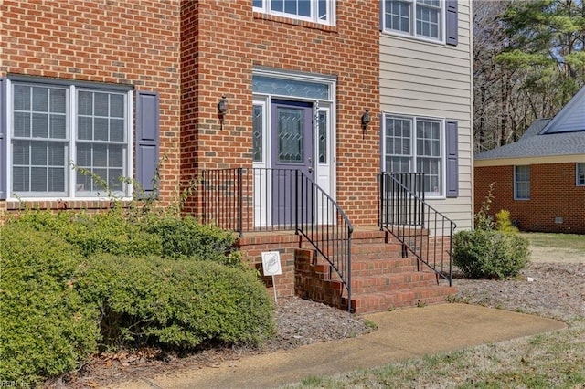 doorway to property featuring brick siding