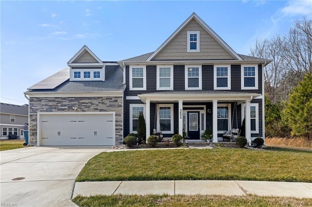 view of front of property featuring driveway, a garage, stone siding, covered porch, and a front lawn