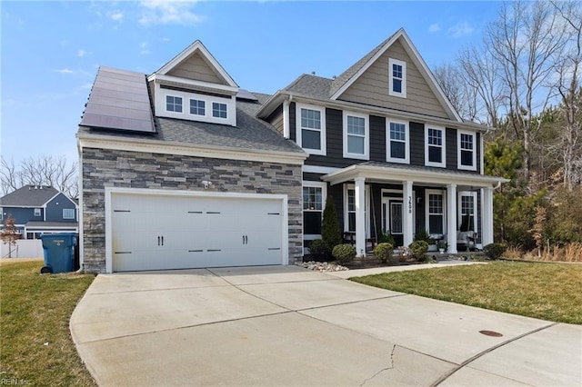 view of front of home featuring stone siding, a porch, concrete driveway, and a front yard