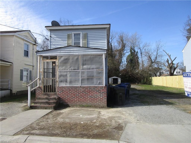 view of front of house featuring a sunroom and fence