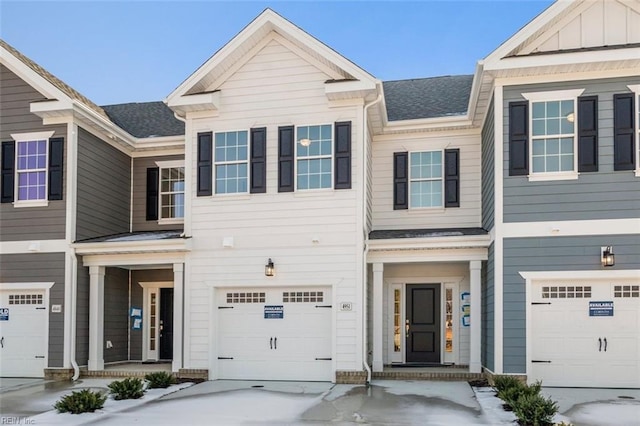 townhome / multi-family property with board and batten siding, driveway, and a shingled roof