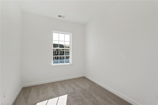 empty room with light carpet, visible vents, and baseboards