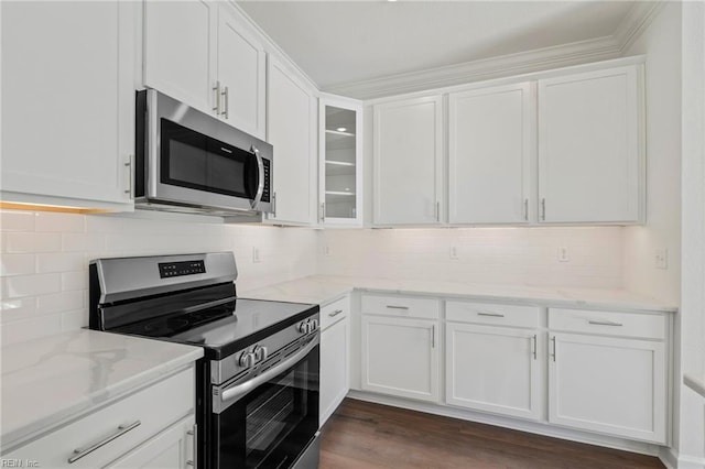 kitchen featuring glass insert cabinets, light stone counters, stainless steel appliances, white cabinetry, and backsplash