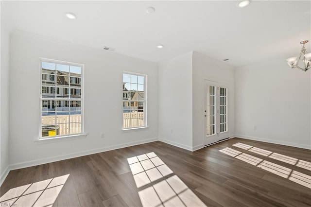 unfurnished room with a chandelier, baseboards, wood finished floors, and recessed lighting