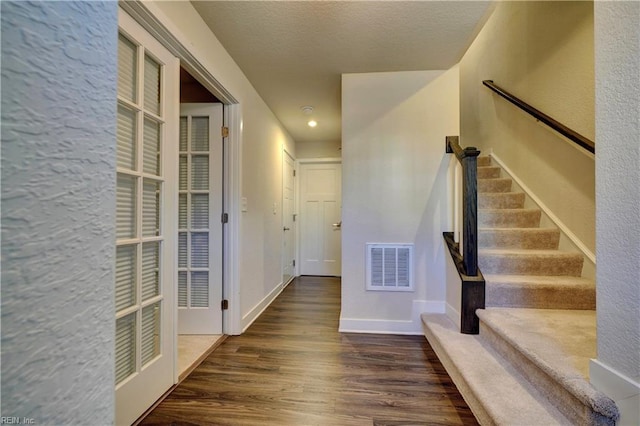 interior space with baseboards, visible vents, and wood finished floors