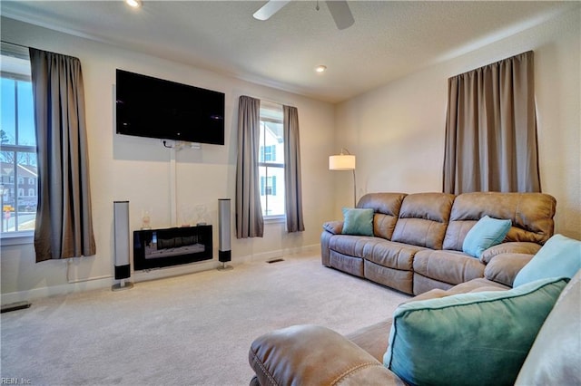 carpeted living room featuring ceiling fan, recessed lighting, visible vents, and baseboards