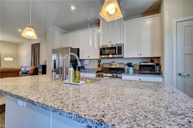 kitchen with stainless steel appliances, a large island, a sink, and white cabinetry