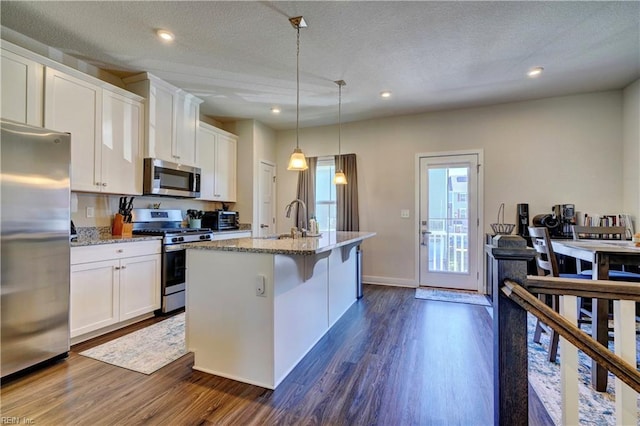 kitchen featuring white cabinetry, appliances with stainless steel finishes, dark wood-style flooring, and a sink