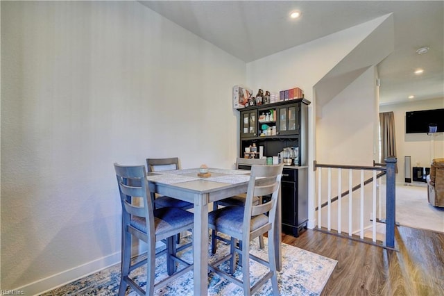 dining space with baseboards, wood finished floors, and recessed lighting