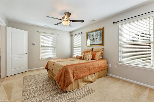 bedroom featuring visible vents, ceiling fan, light carpet, and baseboards