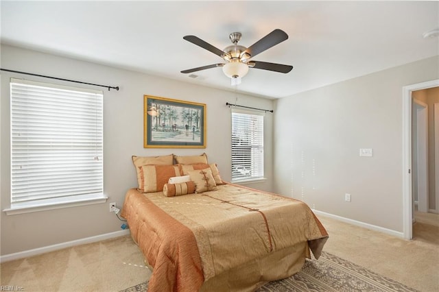 bedroom featuring light carpet, ceiling fan, and baseboards