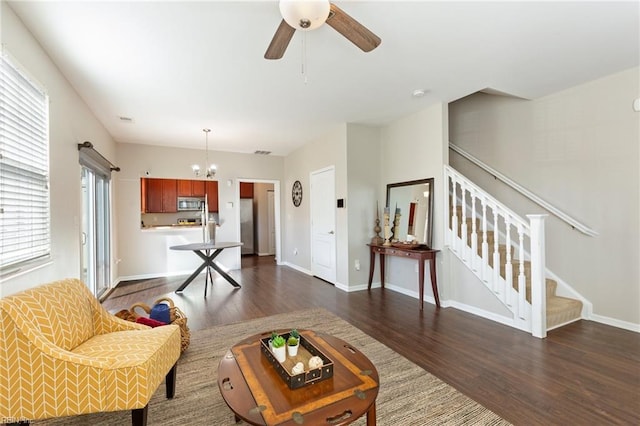 living room featuring stairway, dark wood-style flooring, and baseboards