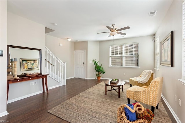 living area with visible vents, ceiling fan, wood finished floors, baseboards, and stairs