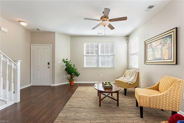 living area featuring stairway, baseboards, visible vents, and wood finished floors