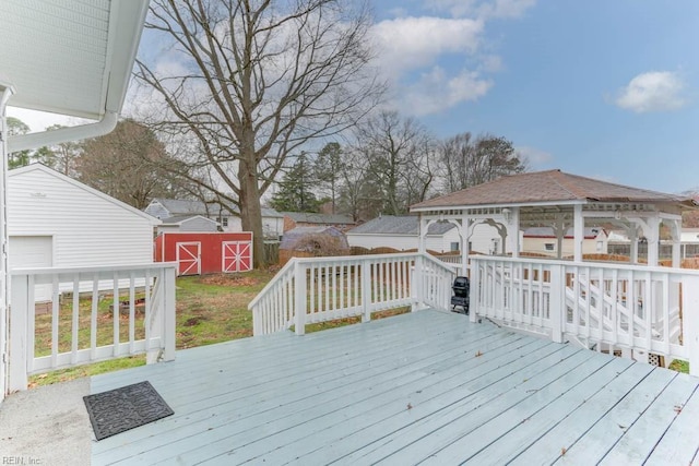 deck with a gazebo, a storage unit, and an outdoor structure