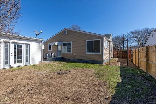 rear view of house featuring a yard and a fenced backyard