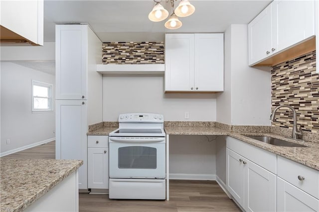 kitchen with light wood finished floors, backsplash, white electric range, white cabinetry, and a sink