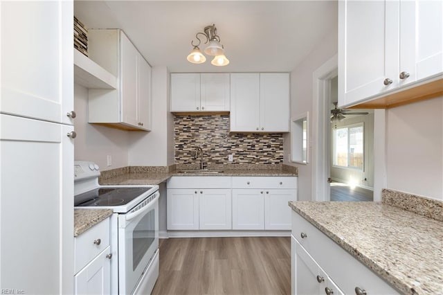 kitchen with white electric stove, a sink, white cabinets, light wood-type flooring, and decorative backsplash